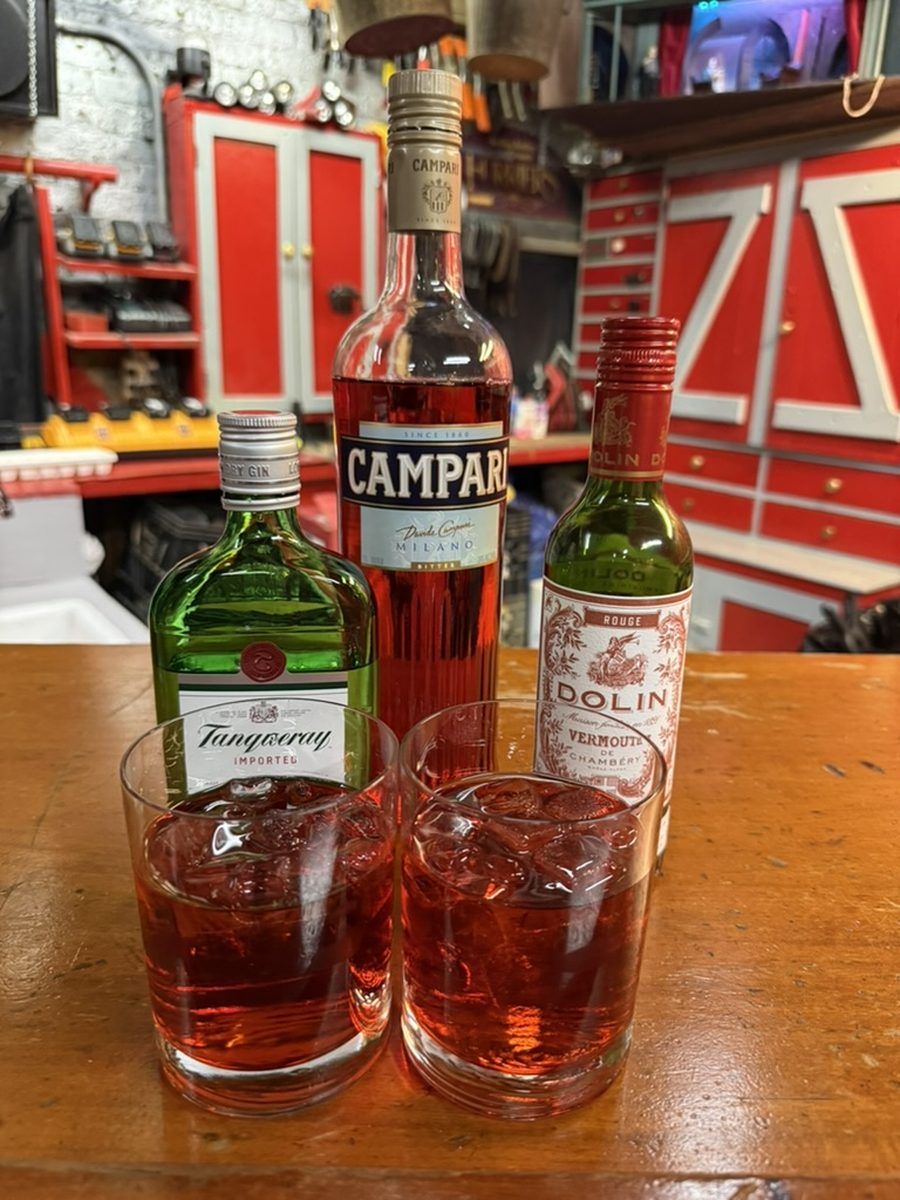 Two Negronis on a wooden bar at the Amateur Comedy Club